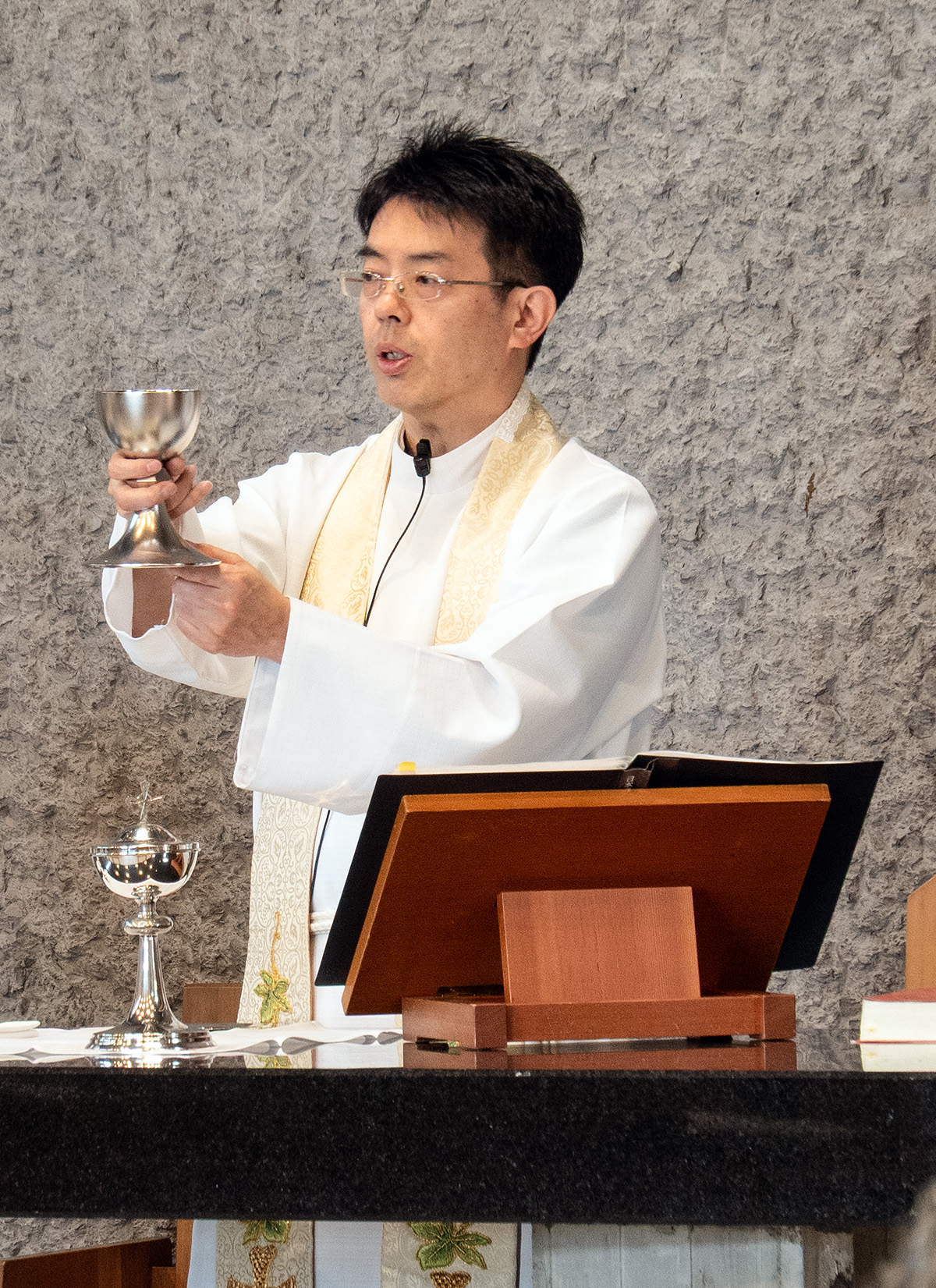 聖餐式で牧師がチャリス（杯）をかかげてワインを聖別している