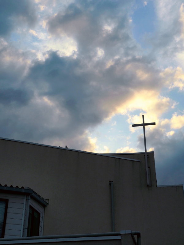 雲を背景に聖堂と十字架の写真