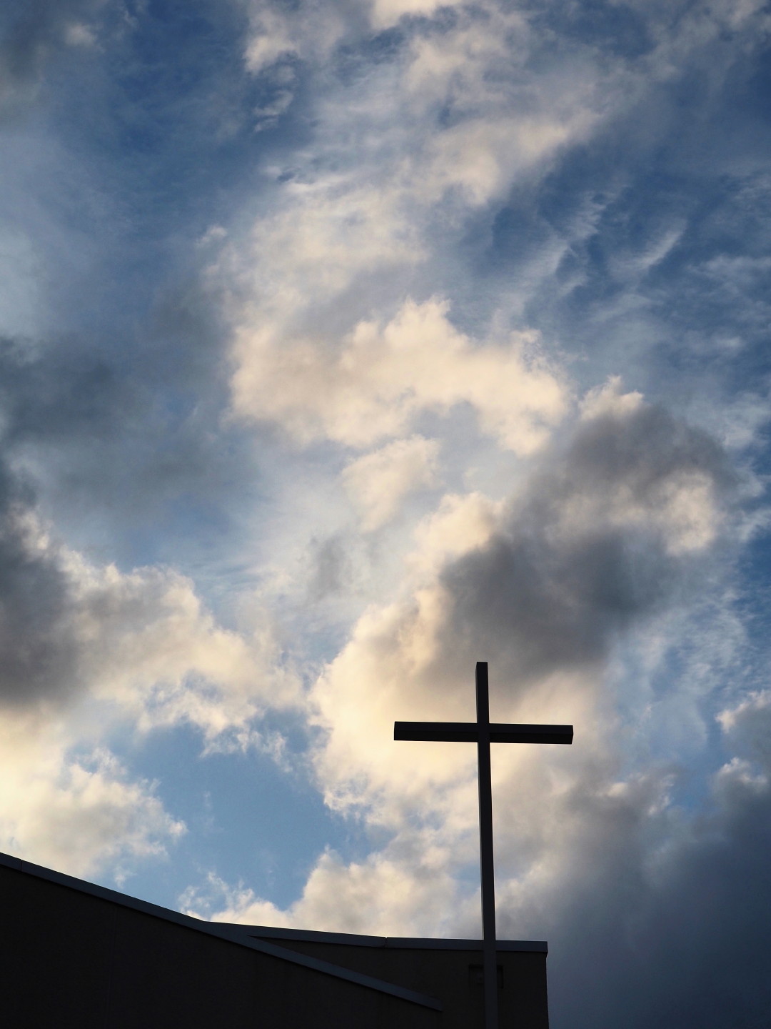 雲に向かって立つ教会の十字架